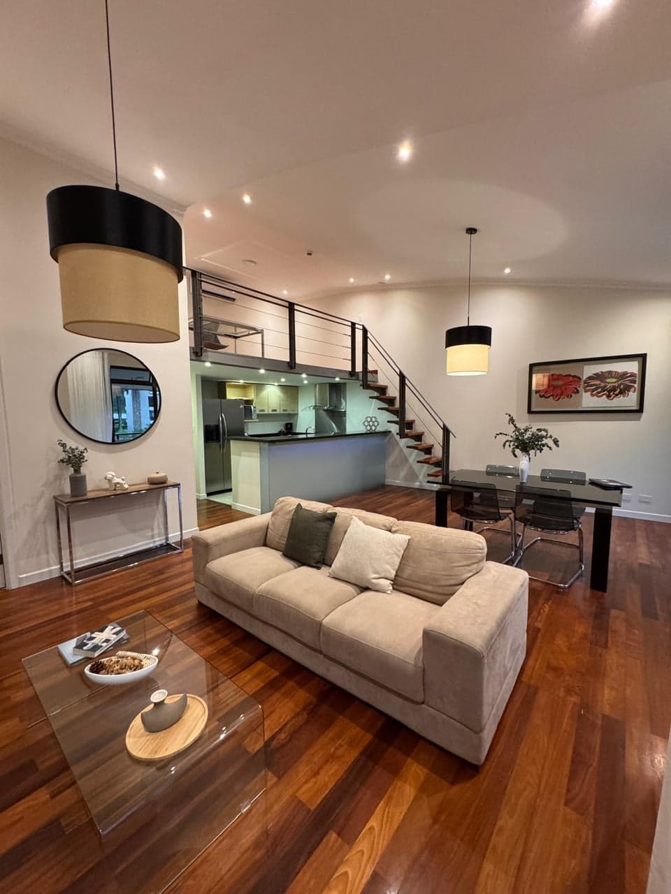 Sala y comedor de doble altura, con la cocina y la escalera al mezzanine