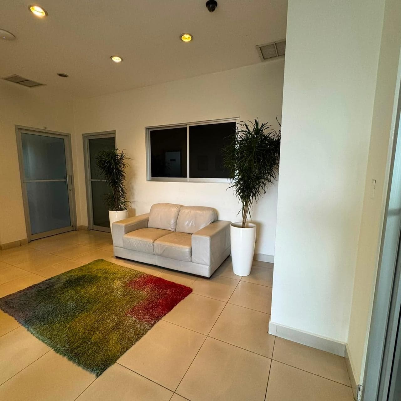 Sala de espera con sofá y alfombra