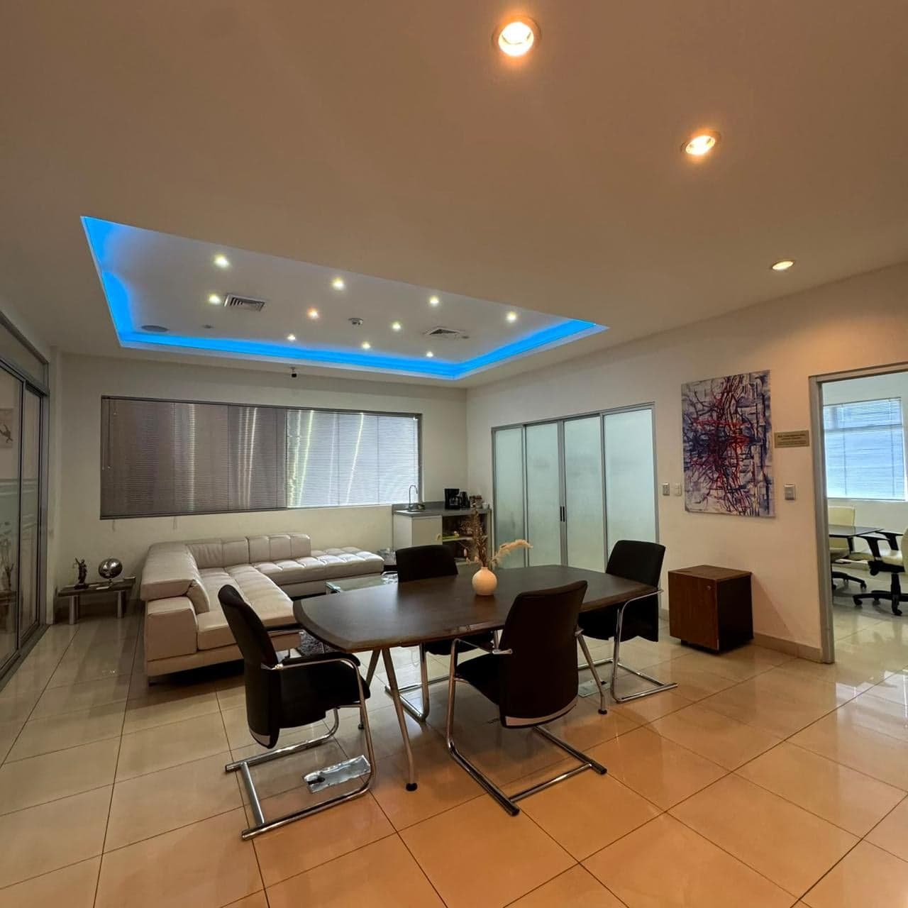 Área común con mesa de reuniones y sala
