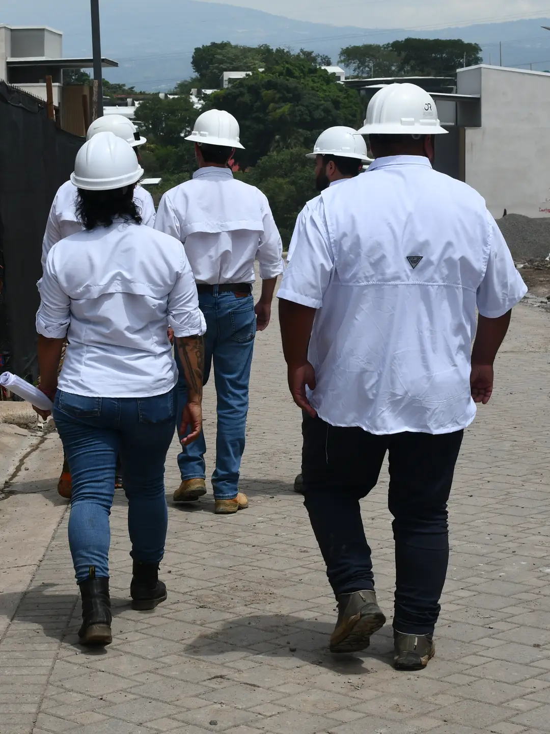 El equipo de Grupo Avalon recorre a pie una obra en construcción, con las montañas al fondo